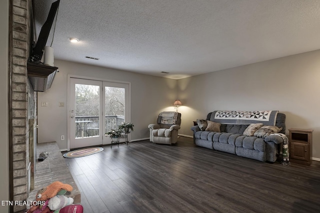 living room featuring dark wood-type flooring and a textured ceiling