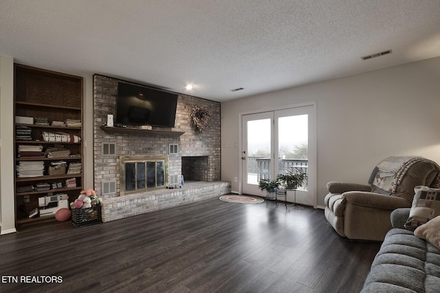 living room with dark hardwood / wood-style floors, a fireplace, and a textured ceiling