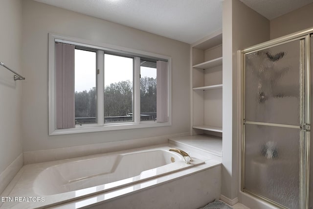 bathroom featuring built in features, separate shower and tub, and a textured ceiling