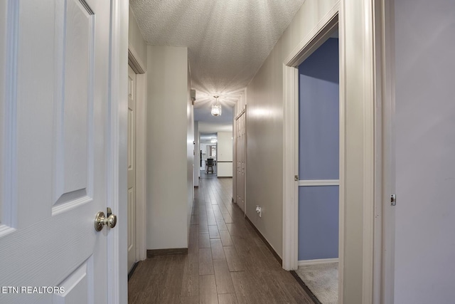 hallway featuring hardwood / wood-style flooring and a textured ceiling