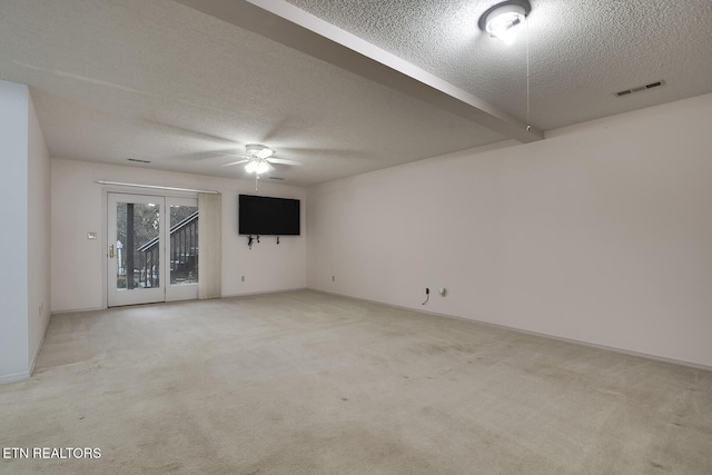 spare room with light carpet, ceiling fan, and a textured ceiling