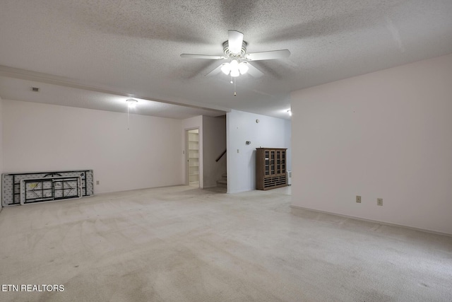 basement with ceiling fan, light carpet, and a textured ceiling