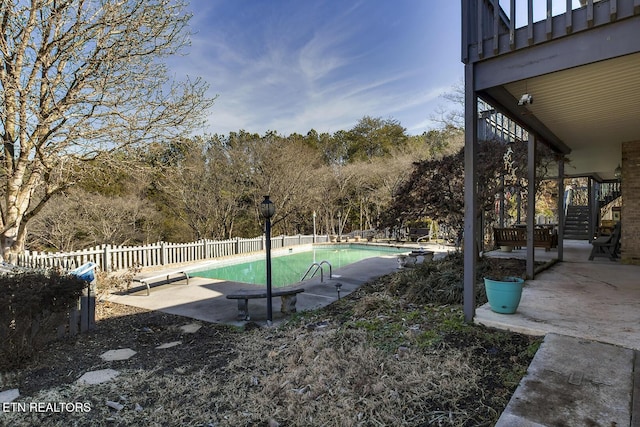 view of swimming pool featuring a diving board and a patio area