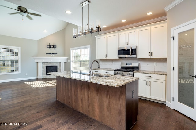 kitchen featuring appliances with stainless steel finishes, sink, a center island with sink, and white cabinets