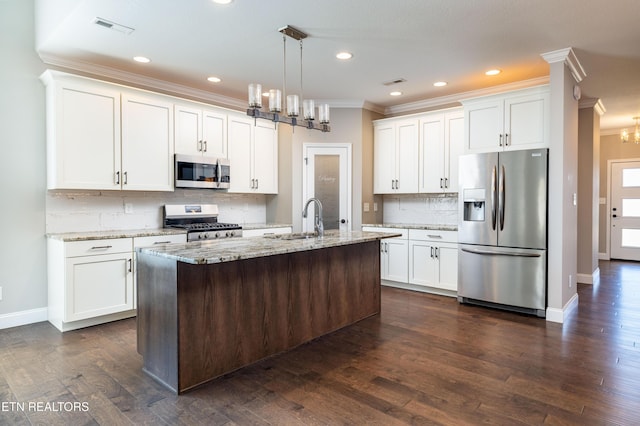 kitchen featuring light stone counters, an island with sink, pendant lighting, stainless steel appliances, and white cabinets