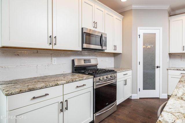 kitchen with appliances with stainless steel finishes, dark hardwood / wood-style floors, white cabinets, crown molding, and light stone countertops