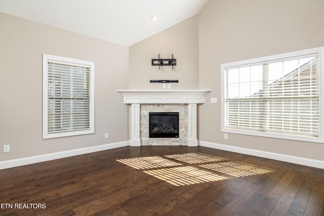 unfurnished living room featuring dark wood-type flooring and high vaulted ceiling