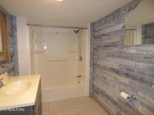 bathroom with vanity,  shower combination, tile patterned flooring, and wood walls