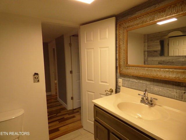 bathroom with vanity, wood-type flooring, and toilet