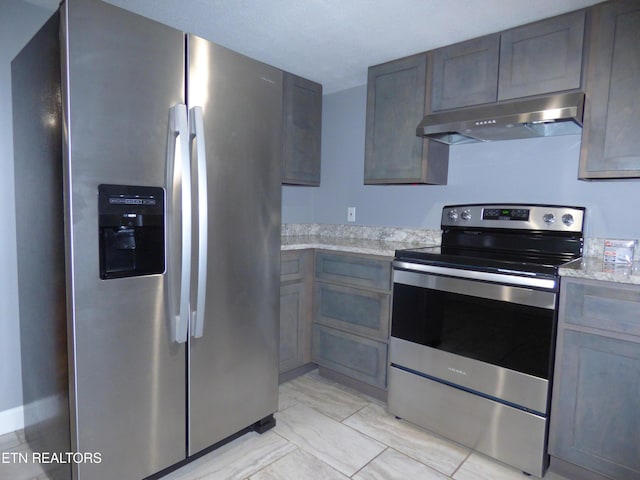 kitchen with light stone countertops and appliances with stainless steel finishes