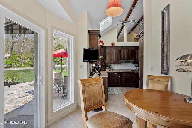 dining space with light tile patterned floors, high vaulted ceiling, and ceiling fan