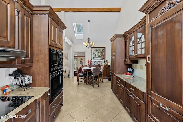 kitchen with glass insert cabinets, light stone counters, an inviting chandelier, hanging light fixtures, and black appliances