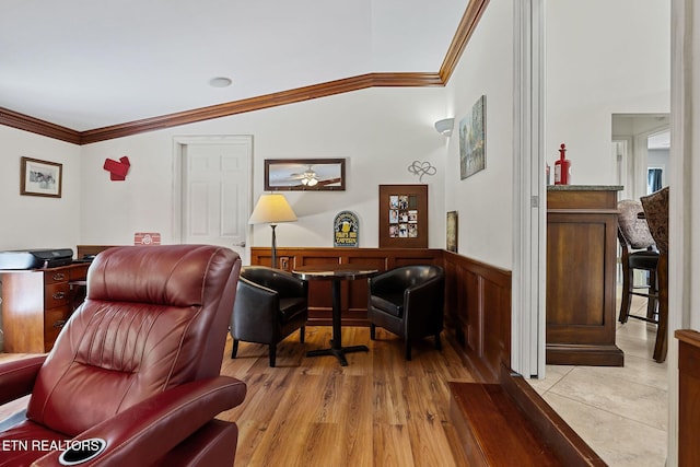 interior space featuring crown molding, light wood finished floors, and wainscoting