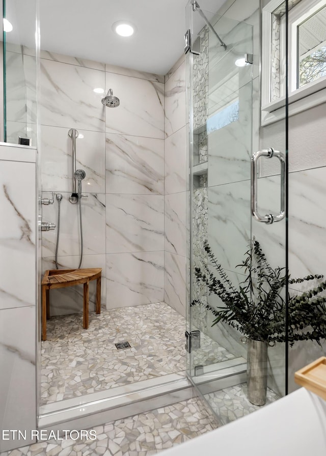 full bathroom featuring a marble finish shower