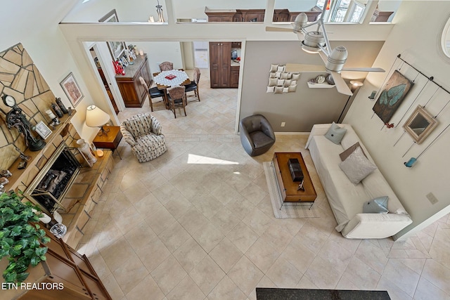 living area with light tile patterned flooring, a fireplace, and baseboards