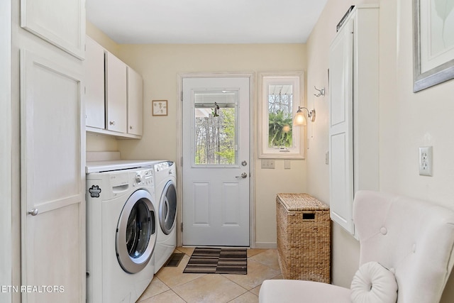 laundry room with washing machine and clothes dryer, light tile patterned floors, and cabinet space