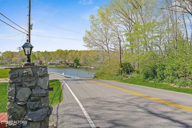 view of street featuring a view of trees and a water view