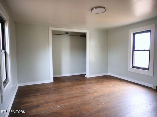 unfurnished bedroom featuring dark hardwood / wood-style floors and a closet