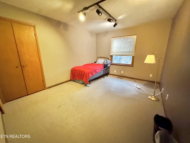 unfurnished bedroom featuring carpet floors and track lighting