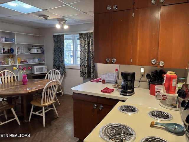 kitchen featuring a paneled ceiling and dark parquet floors