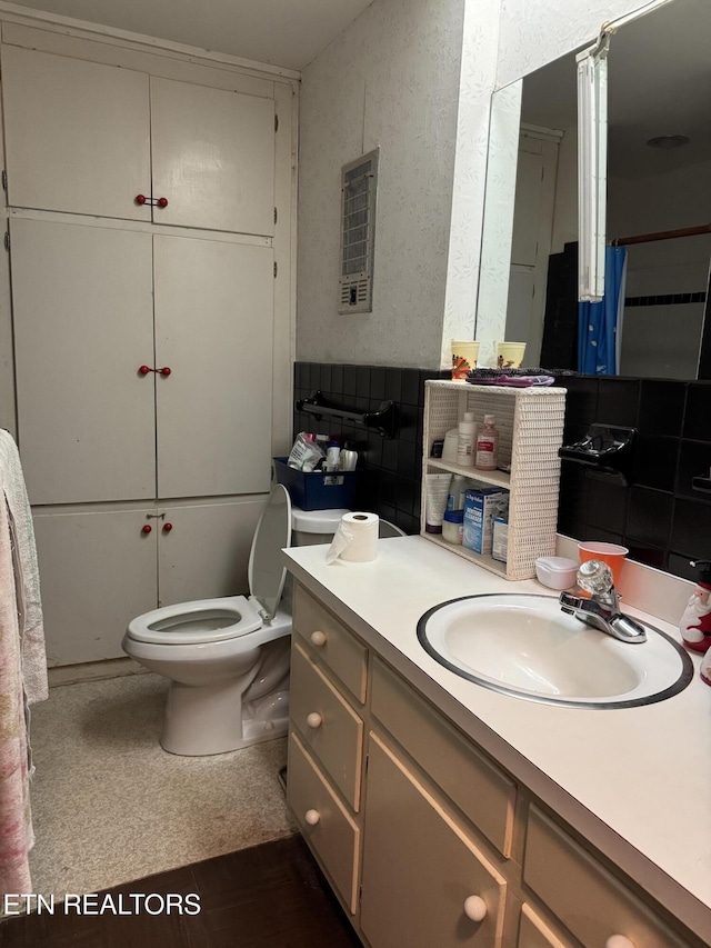 bathroom with vanity, toilet, and backsplash