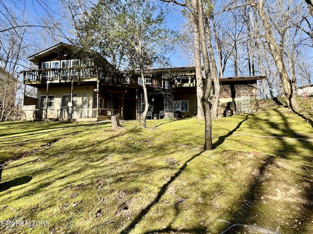 back of house featuring a wooden deck and a lawn