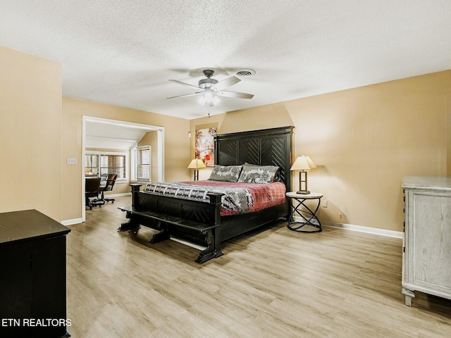 bedroom featuring ceiling fan, a textured ceiling, and light wood-type flooring