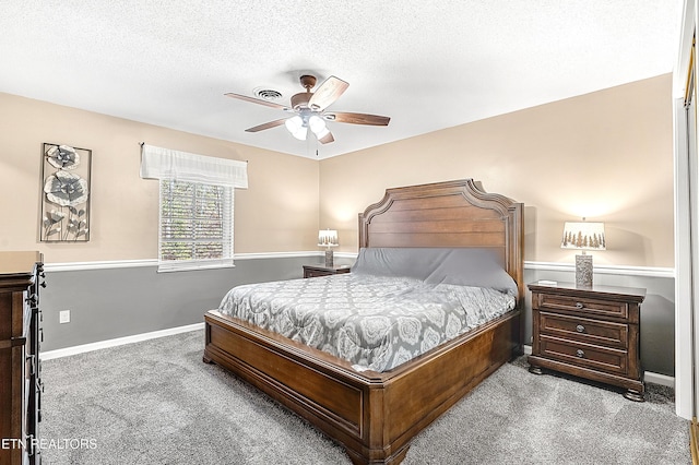 carpeted bedroom featuring ceiling fan and a textured ceiling