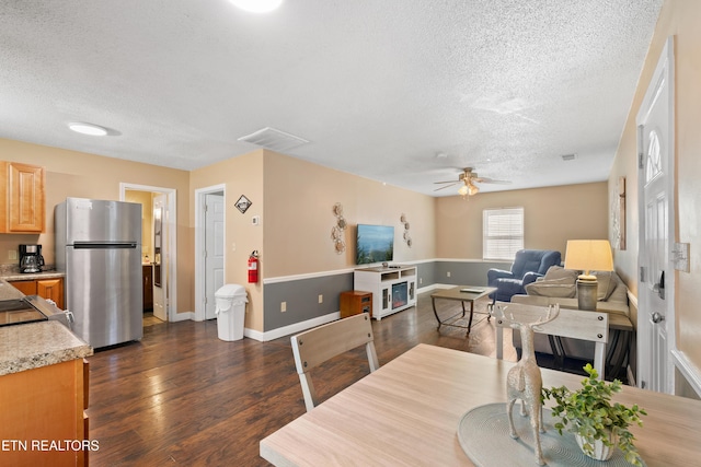 dining room with ceiling fan, a textured ceiling, and dark hardwood / wood-style flooring