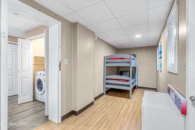 clothes washing area with washer / clothes dryer and wood-type flooring