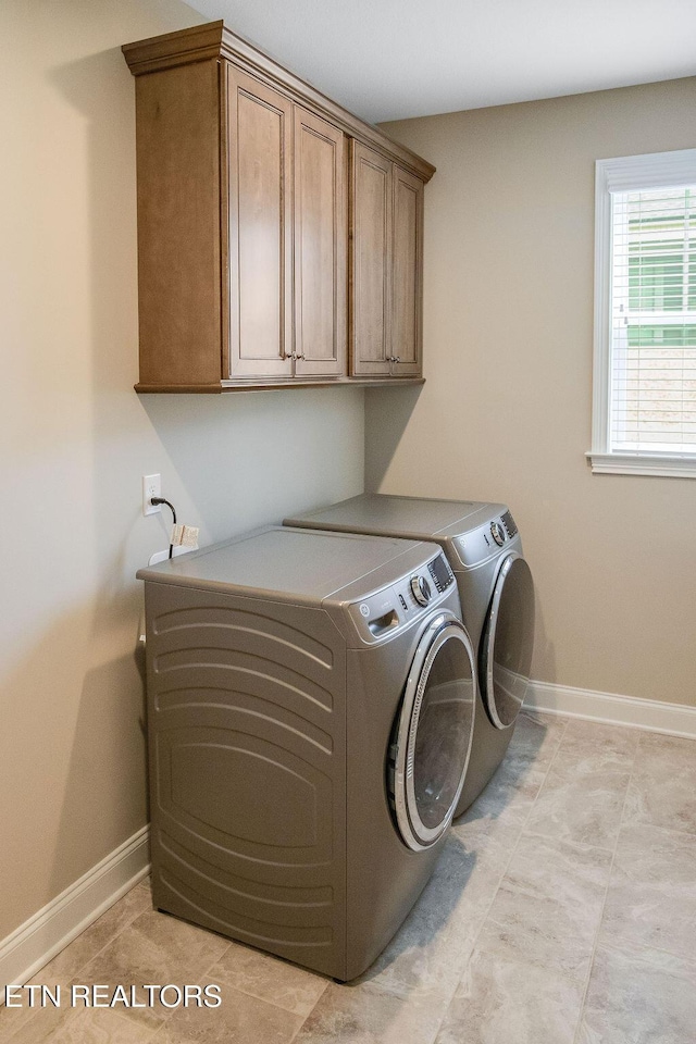 laundry room with baseboards, cabinet space, and washing machine and clothes dryer