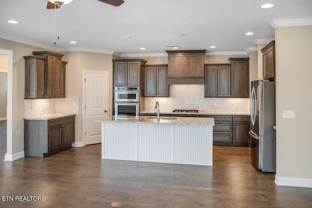 kitchen featuring dark wood-style floors, appliances with stainless steel finishes, an island with sink, and a sink