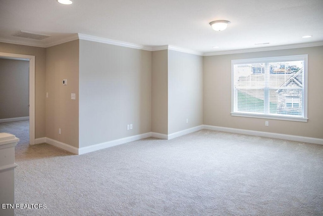 spare room with light carpet, baseboards, and crown molding