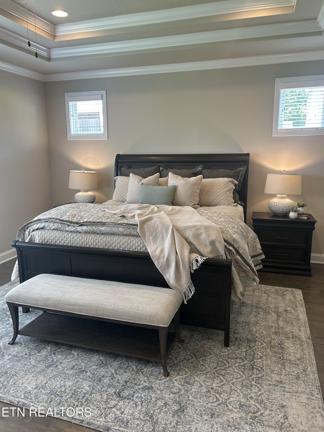 bedroom with baseboards, a raised ceiling, wood finished floors, crown molding, and recessed lighting