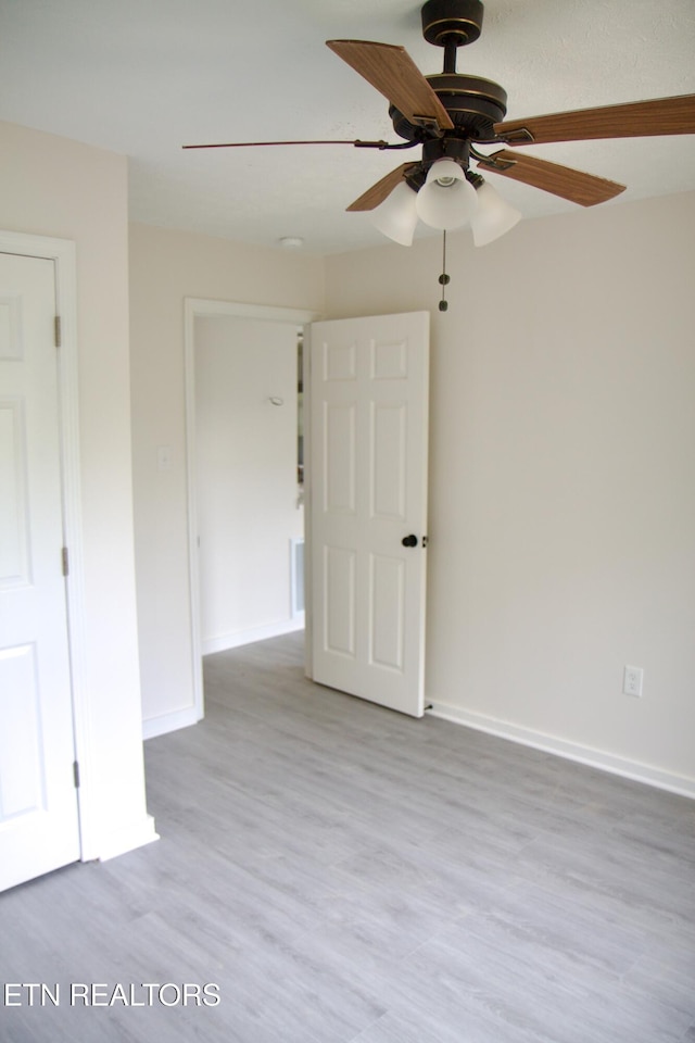 empty room with ceiling fan and light wood-type flooring