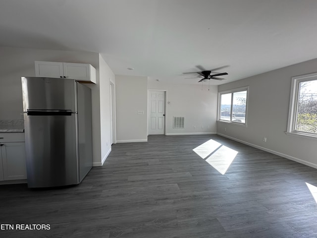 unfurnished living room featuring dark hardwood / wood-style flooring and ceiling fan