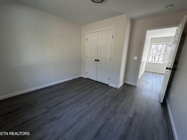 unfurnished bedroom featuring dark hardwood / wood-style floors and a closet