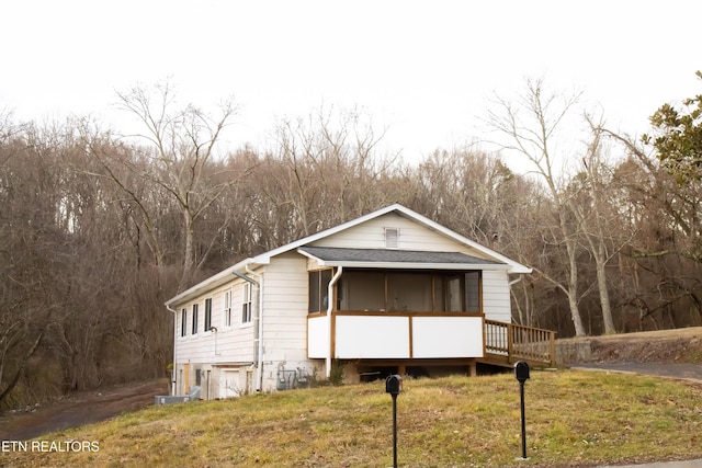 view of front of home featuring a front lawn and a sunroom