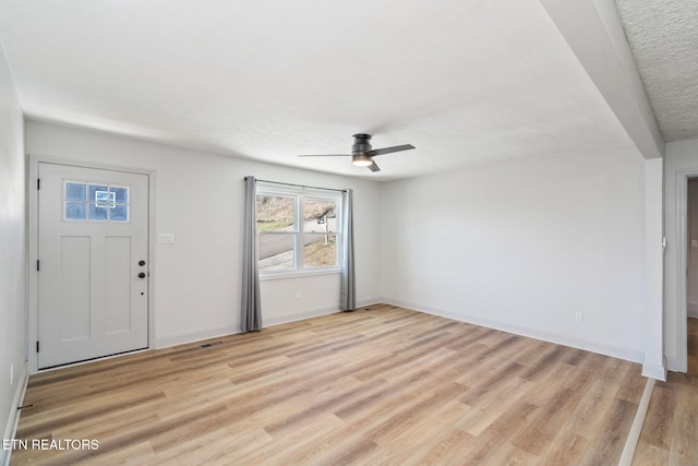 foyer entrance featuring ceiling fan, a textured ceiling, and light wood-type flooring