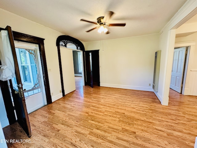 empty room with ceiling fan, a textured ceiling, and light hardwood / wood-style floors