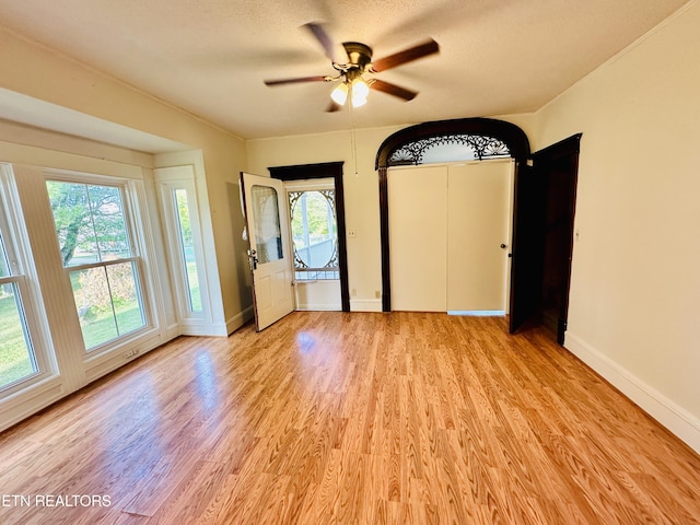 interior space with ceiling fan, light hardwood / wood-style flooring, and a textured ceiling