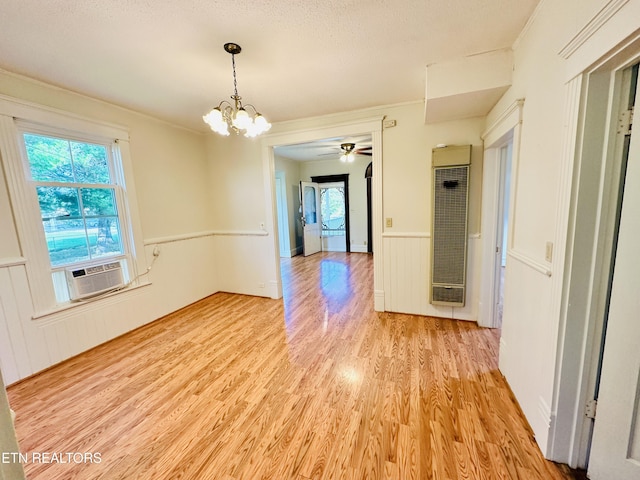 unfurnished dining area with cooling unit, an inviting chandelier, crown molding, and light hardwood / wood-style floors