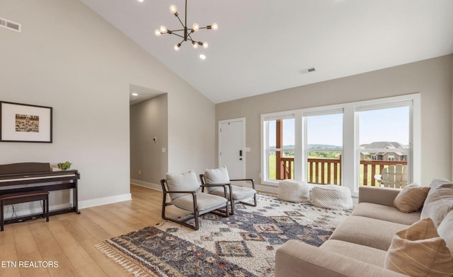 living room featuring high vaulted ceiling, light wood-type flooring, and a chandelier