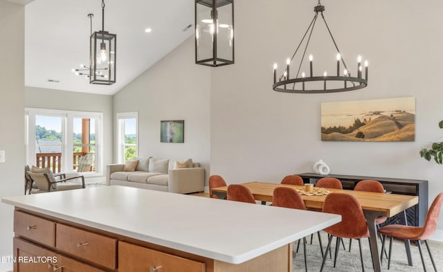 kitchen featuring pendant lighting, high vaulted ceiling, a center island, and a chandelier