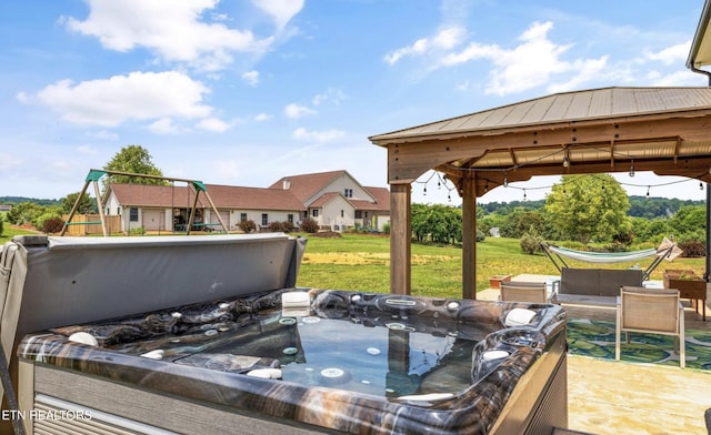 view of patio featuring a gazebo, a hot tub, and a playground