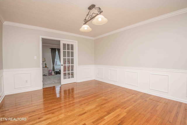 unfurnished room featuring wood-type flooring, crown molding, and french doors