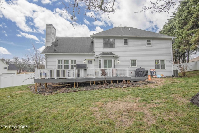 rear view of house featuring a wooden deck, central AC unit, and a lawn