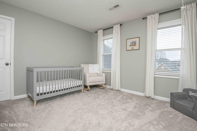 bedroom with a nursery area and light colored carpet