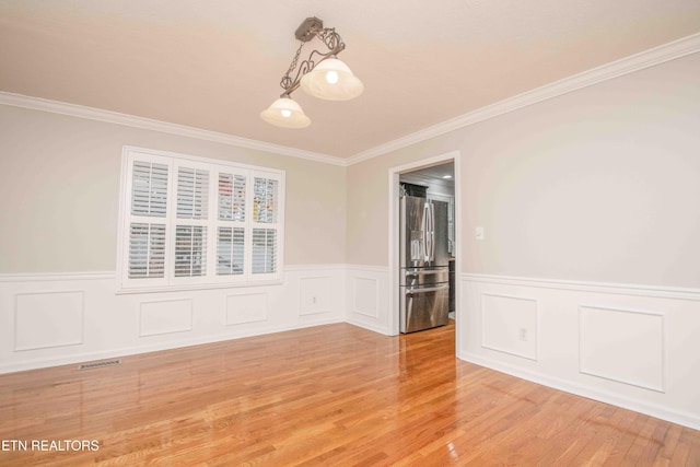 spare room with crown molding and hardwood / wood-style floors