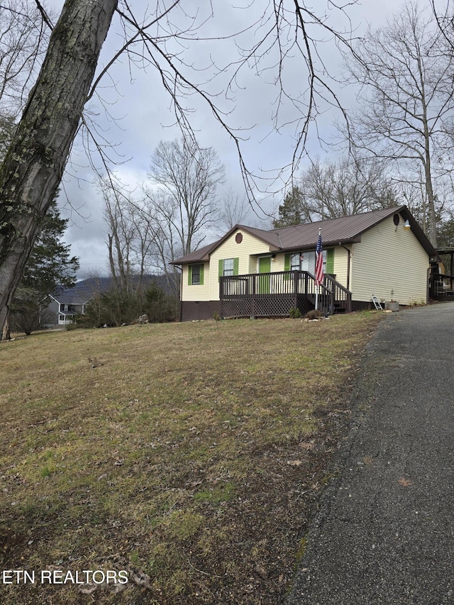 view of front of house featuring a front yard and a wooden deck